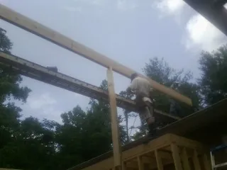 Carpenter setting a ridge beam over a new addition frame — Ice Dam Removal by Roofing Brothers in Doylestown